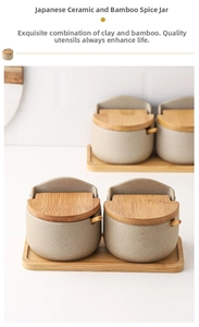Detail of Japanese ceramic seasoning pots with bamboo lids and spoons on a wood tray
