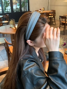 Close-up of wide grey-blue velvet headband worn by a model for an elegant autumn style
