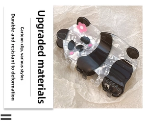 Detail of panda hair claw clip made of pearlescent acrylic with pink flower decor