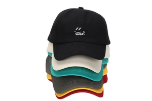 Close-up of colorful cotton baseball caps with smile embroidery stacked vertically