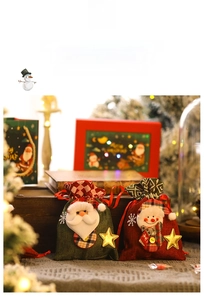 Detailed view of Santa and Snowman drawstring gift bags with 3D plush and gold stars