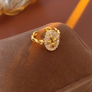Vue macro de la bague fleur de lys dorée avec zircone sur boîte à bijoux en velours