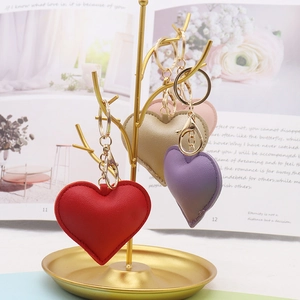 Close-up of heart-shaped PU leather keychains in red, purple, gold, and pink colors