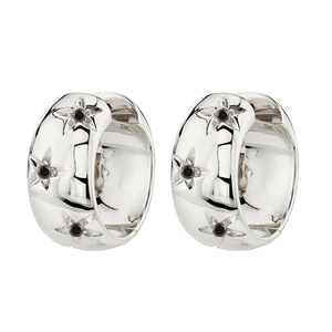 Detail of silver hoop earrings featuring star engravings and black zircon stones