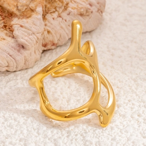 Irregular gold stainless steel open ring with abstract organic lines on white texture