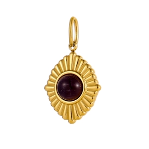 Detailed view of vintage gold pendant with radial texture and purple gemstone inlay