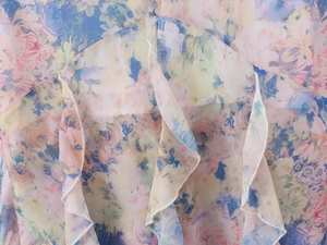 Detailed macro view of colorful floral chiffon fabric with ruffled edges and fine stitching