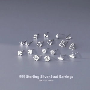 Detailed close-up of multiple S999 sterling silver stud earrings in various geometric shapes