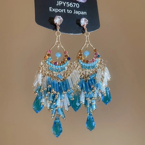 Detailed view of silver needle drop earrings with blue crystal fringe in French style