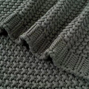 Nordic style dark grey knitted blanket with fringe details and soft textured weave