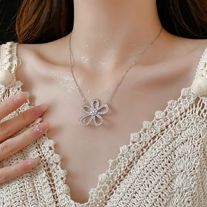 Gros plan d'un collier pendentif fleur argenté avec zircons sur le cou d'un mannequin