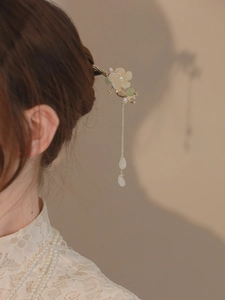 Détail d'épingle à cheveux fleur de magnolia blanche avec de longs pompons et perles
