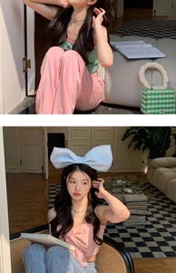 Detail showing an oversized light blue bow headband accessory and pink bow top on a model