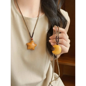 Detailed view of handmade wooden star and moon pendants with woven rope cord