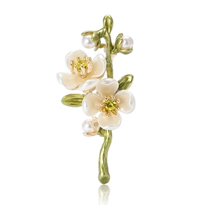 Elegant enamel plum blossom branch brooch with yellow crystals and pearls on white background
