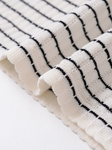 Gros plan du tissu tricoté blanc avec rayures horizontales noires et texture douce