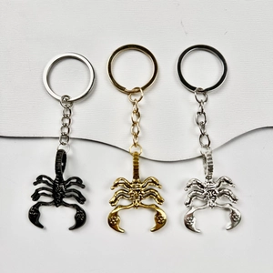Creative alloy scorpion keychains in black, gold, and silver finishes on a split background