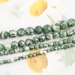 Vue macro de perles en pierre naturelle à points verts en plusieurs tailles pour bijoux