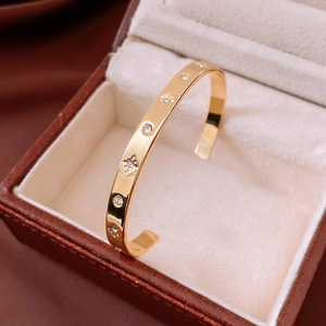 Detail of 18K gold-plated C-shaped cuff with star engravings and crystal inlays