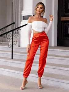 Detailed view of high-waist bright orange satin cargo pants with side pockets for women