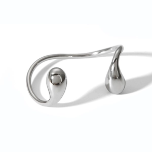 Macro detail of silver streamline metal bangle with drop-shaped ends and mirror finish