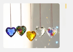 Detail of five colorful heart-shaped crystal suncatchers showing light refraction