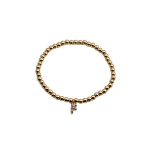Close-up of gold beaded stretch bracelet featuring a colorful pave zircon letter F charm