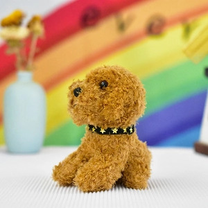 Close-up of a cute brown curly plush poodle dog toy with a star collar detail.