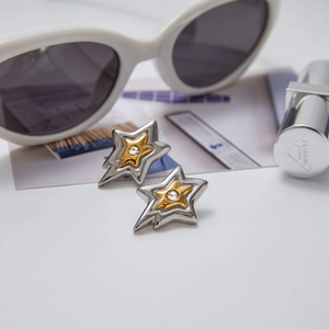 Macro view of two-tone star earrings with crystal center and silver-gold metal finish