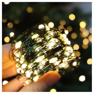 Detail of hand-held warm white firefly LED string lights with soft bokeh background