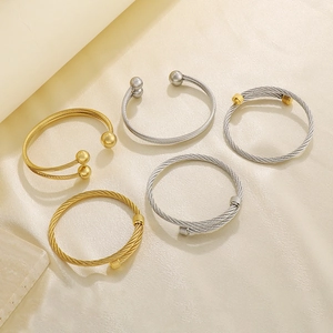 Macro shot of twisted wire cable bracelets in gold and silver stainless steel textures