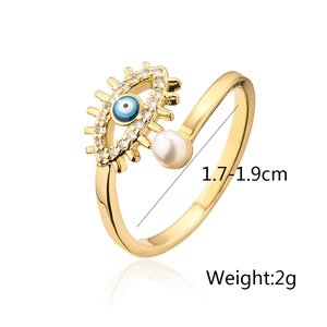 Detailed view of evil eye open ring with blue enamel, pearl and zircons in gold finish