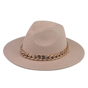 Detail of apricot straw fedora hat featuring a stylish thick golden chain embellishment