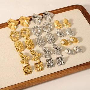 Französische Vintage-Ohrringe in Gold und Silber auf einem Holztablett mit Perlenbesatz