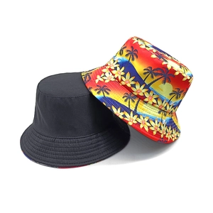 Reversible bucket hat with coconut tree print and plain black side for beach sun protection