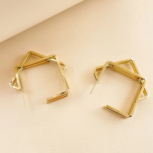 Close-up of golden double-layer geometric square stud earrings with polished finish