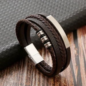 Detail of multi-layer brown braided leather bracelet with silver metal plate and magnetic clasp