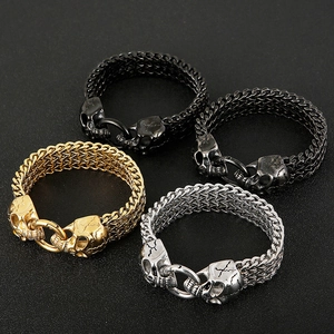 Detail of gothic punk woven chain bracelets with skull heads in gold silver and black finish