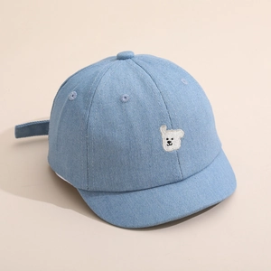 Gros plan détaillé d'une casquette en jean pour bébé avec broderie d'ours blanc et coutures