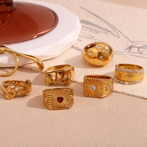 Macro view of 18K gold-plated rings with hammered textures and heart-shaped gemstones