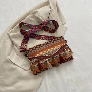 Detail of bohemian woven crossbody bag featuring colorful tassels and geometric patterns