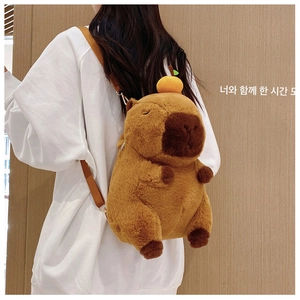 Detail of soft capybara plush backpack with orange head decor and adjustable straps