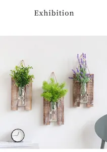 Detalle de decoración de pared en madera con jarrones de vidrio y plantas artificiales