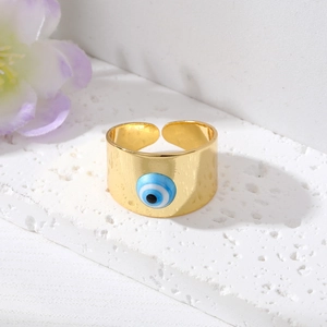 Détail d'une bague Evil Eye plaquée or sur socle en pierre avec décor floral