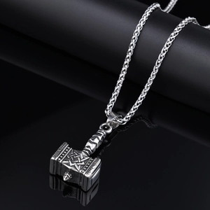 Vintage silver Mjolnir pendant with intricate Norse carvings and woven wheat chain