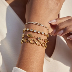 Set di quattro bracciali in acciaio inossidabile dorato con strass indossati sul polso