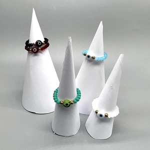 Set of four stretch evil eye beaded rings in black, green, light blue and white colors