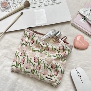 Gros plan d'une trousse à maquillage en toile aux tulipes roses avec étiquette Sozakka