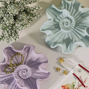 Macro detail of seashell spiral jewelry tray in pastel blue and purple matte finish