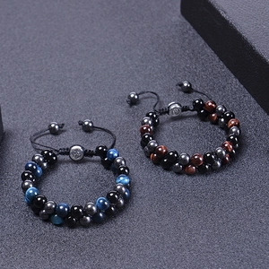 Detail of double-layer blue tiger eye and black stone beaded bracelets with woven cord